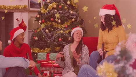 Animation-of-stars-over-diverse-friends-sitting-at-christmas
