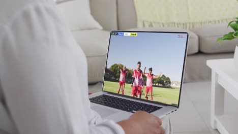 Video-Eines-Kaukasischen-Mannes,-Der-Auf-Dem-Sofa-Sitzt-Und-Zu-Hause-Auf-Dem-Laptop-Fußball-Schaut