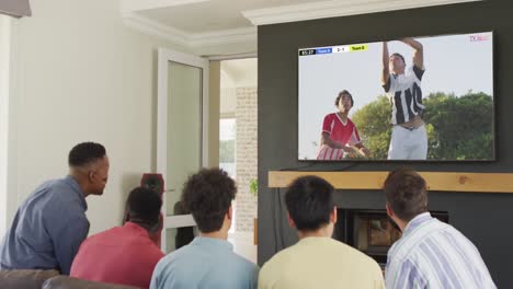 Diverse-friends-supporting-and-watching-tv-with-diverse-male-soccer-players-playing-match-on-screen