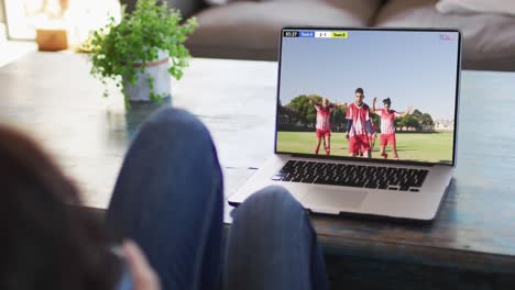 Video-Einer-Frau,-Die-Auf-Dem-Sofa-Sitzt-Und-Zu-Hause-Auf-Dem-Laptop-Fußball-Schaut