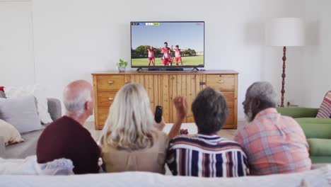 Video-Von-Verschiedenen-älteren-Freunden,-Die-Auf-Dem-Sofa-Sitzen-Und-Zu-Hause-Fußball-Schauen