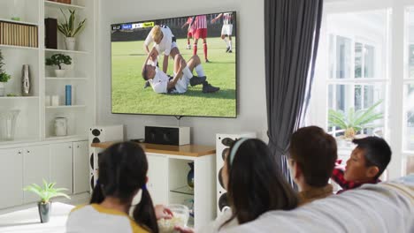 Video-of-diverse-group-of-children-sitting-on-the-couch-and-watching-football-match