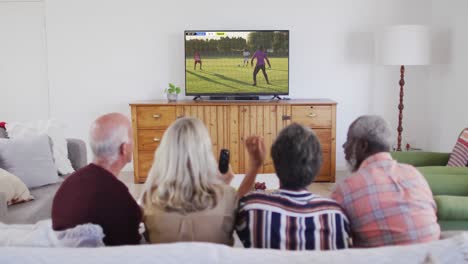 Video-Einer-Gruppe-älterer-Menschen,-Die-Auf-Der-Couch-Sitzen-Und-Sich-Ein-Fußballspiel-Ansehen
