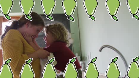 Animation-of-pear-icons-over-caucasian-woman-with-son-in-kitchen