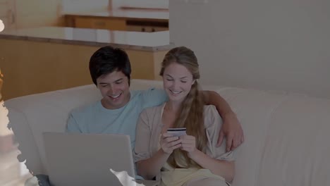 Animation-of-shapes-over-diverse-couple-using-laptop-for-online-shopping