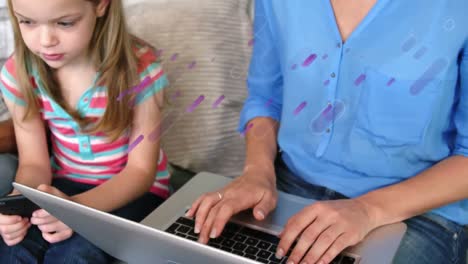 Animation-of-shapes-over-caucasian-mother-and-daughter-using-laptop