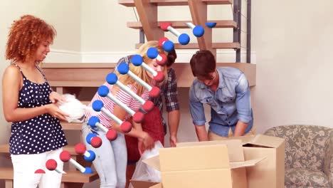 Animation-of-dna-over-happy-caucasian-friends-moving-into-new-house
