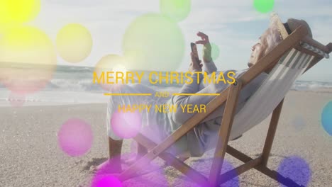 Animation-of-merry-christmas-text-over-senior-biracial-man-at-beach