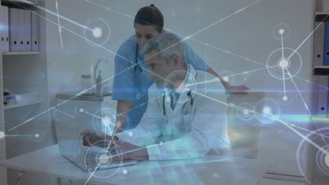 Animation-of-dots-connected-with-lines-and-lens-flare-over-caucasian-doctors-discussing-over-laptop