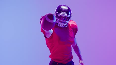 Video-of-caucasian-american-football-player-in-helmet-with-ball-over-neon-purple-background