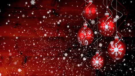 Animation-of-christmas-baubles-over-snow-falling