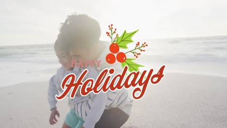 Animation-of-happy-holidays-text-over-biracial-father-and-son-at-beach
