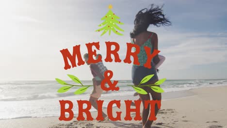 Animation-of-merry-and-bright-text-over-biracial-family-at-beach
