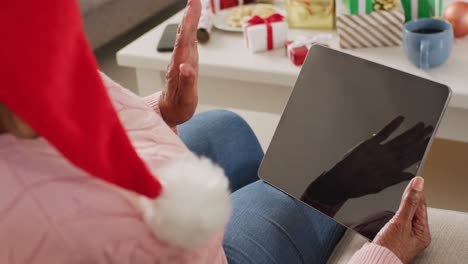 Happy-senior-african-american-woman-having-video-call-using-tablet-with-copy-space-at-christmas