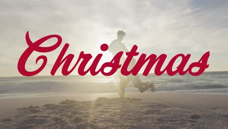 Animation-of-christmas-text-over-biracial-man-and-his-son-at-beach