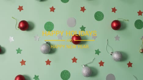 Animation-of-happy-holidays-over-stars-and-baubles-on-green-surface