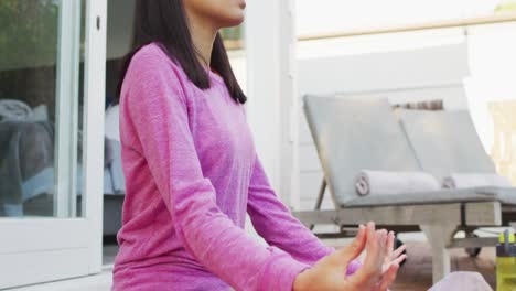 Mujer-Birracial-Practicando-Yoga-Y-Meditando-En-El-Jardín.