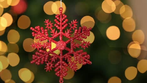 Animation-of-snowflake-docoration-over-light-spots-on-green-background