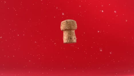 Animation-of-snow-falling-over-cork-on-red-background