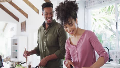 Glückliches-Afroamerikanisches-Paar,-Das-In-Der-Küche-Kocht-Und-Redet