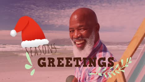 Animation-of-seasons-greetings-text-and-santa-hat-over-happy-senior-african-american-man-on-beach