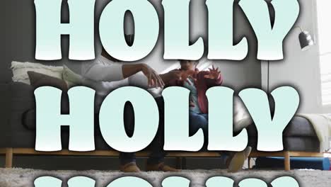 Animation-Von-Holly-Text,-Der-Zu-Weihnachten-über-Einem-Afroamerikanischen-Paar-In-VR-Headsets-Zu-Hause-Wiederholt-Wird