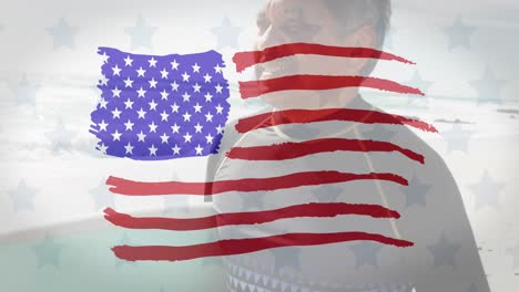 Animation-Der-Flagge-Der-Vereinigten-Staaten-Von-Amerika-über-Einem-älteren-Biracial-Mann-Mit-Surfbrett-Am-Strand