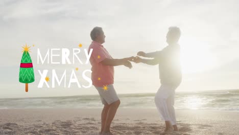 Animation-of-merry-xmas-text-and-tree-over-happy-senior-biracial-couple-dancing-on-sunny-beach