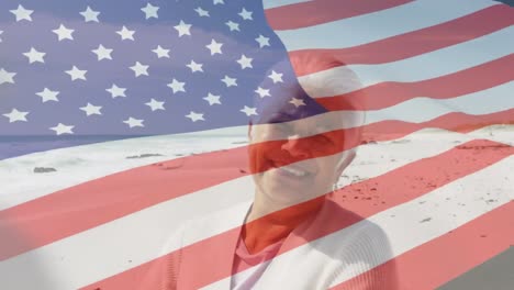 Animation-of-flag-of-united-states-of-america-over-senior-biracial-woman-on-beach
