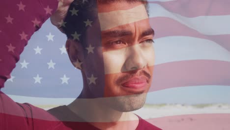 Animation-of-flag-of-united-states-of-america-and-biracial-man-on-beach