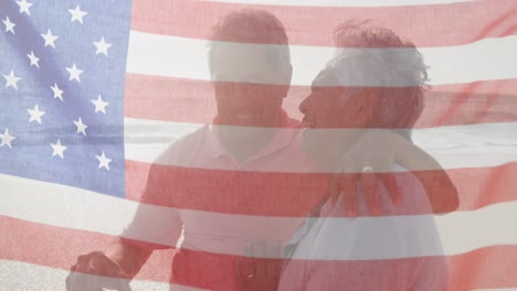 Animation-Der-Flagge-Der-Vereinigten-Staaten-Von-Amerika-über-Ein-älteres-Gemischtrassiges-Paar,-Das-Sich-Am-Strand-Küsst