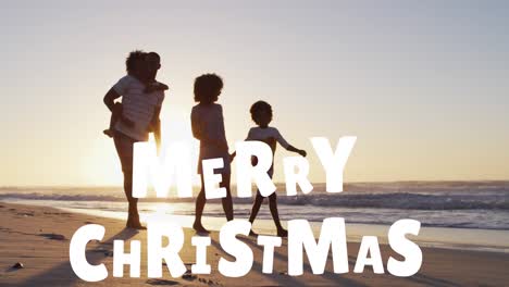 Animation-of-merry-christmas-text-over-happy-african-american-family-walking-on-sunny-beach