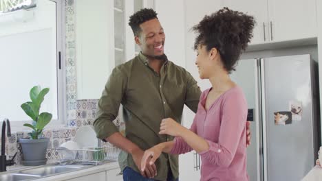 Glückliches-Afroamerikanisches-Paar,-Das-In-Der-Küche-Tanzt-Und-Händchen-Hält