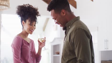 Glückliches-Afroamerikanisches-Paar,-Das-In-Der-Küche-Kocht-Und-Wein-Trinkt