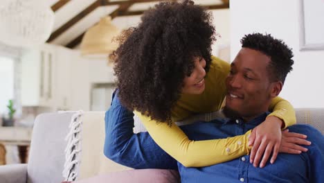 Glückliches-Afroamerikanisches-Paar,-Das-Sich-Im-Wohnzimmer-Umarmt
