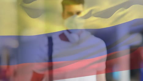 Animation-of-flag-of-colombia-over-caucasian-man-with-face-mask