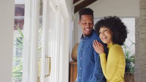 Happy-african-american-couple-embracing-together-at-home
