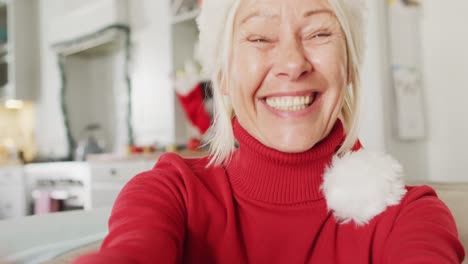 Happy-senior-caucasian-woman-wearing-santa-claus-hat,-having-video-call