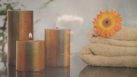 Animation-of-lights-over-candles,-flower-and-towels