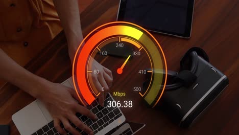 Animation-of-orange-speedometer-over-hands-of-caucasian-woman-using-laptop