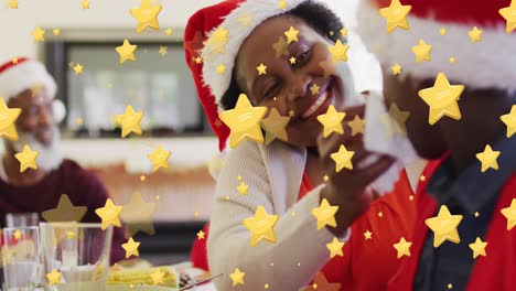 Animation-of-stars-over-african-american-family-wearing-santa-claus-hats