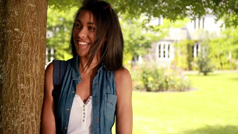 Smiling-student-leaning-against-the-tree