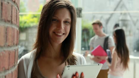 Studentin-Mit-Tablet-Und-Freunde-Sprechen-Hinter-Ihr