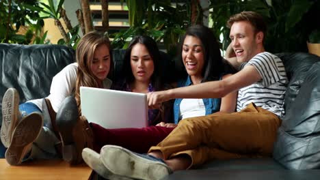 Freunde-Sitzen-Und-Benutzen-Laptop-Auf-Der-Couch