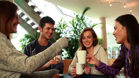 Amigos-Sonrientes-Tomando-Café-Y-Brindando