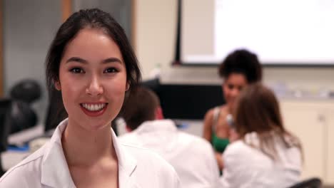 Pretty-medical-student-smiling-at-camera-in-class