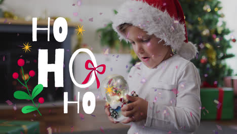 Animation-of-christmas-ho-ho-ho-text-over-caucasian-boy-in-santa-hat-at-christmas