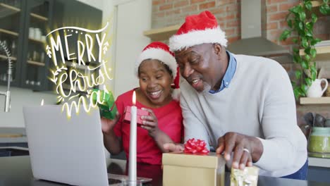 Animation-of-christmas-greetings-text-over-african-american-couple-using-laptop-at-christmas