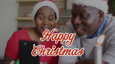 Animation-of-christmas-greetings-text-over-african-american-couple-on-smartphone-call-at-christmas