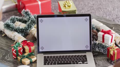 Diversos-Amigos-Usando-Una-Computadora-Portátil-Con-Espacio-De-Copia-En-La-Fiesta-De-Navidad
